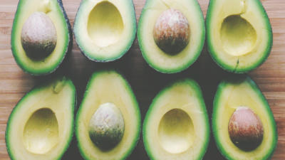 Image of assortment of sliced avocados, some with pits, some without
